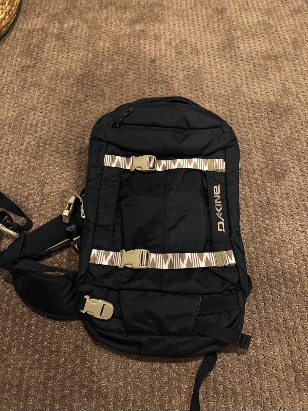 Dakine Black hydration Backpack with Tan Patterned Straps and hip straps